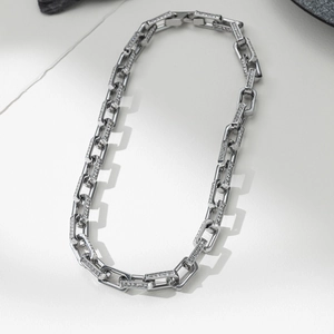 Silver-tone hip hop bamboo link bracelet with sparkling rhinestones on white stone background