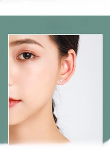 Close-up of minimalist S925 sterling silver heart stud earrings worn by a model