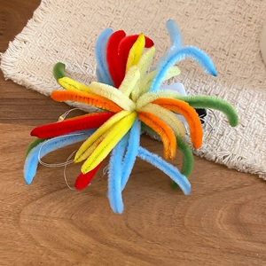 Detailed view of handmade colorful plush firework hair clip with LED light feature