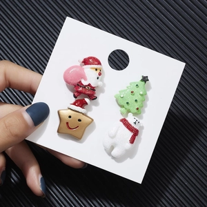 Detailaufnahme von Acryl-Weihnachtsohrringen mit Weihnachtsmann und Rentier auf Karte