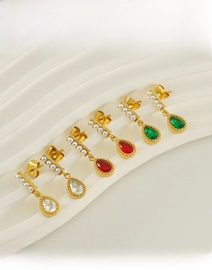 Detail of titanium steel teardrop earrings with pearls in white, red and green stones