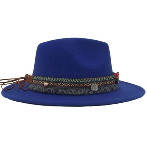 Detail of blue wide-brim cowboy hat featuring ethnic woven band and metallic pendant
