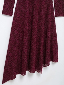 Detail view of the asymmetric lace hemline on a dark red elegant cocktail dress