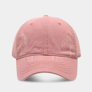 Close-up of pink distressed cotton baseball cap with vintage worn details and curved brim