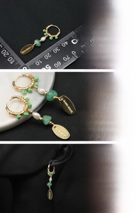Detailed view of handmade pearl earrings with 18K gold plating and green gemstones