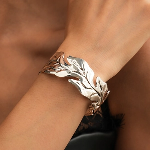 Detailed close-up showing the realistic leaf texture and veins on the silver metal cuff bracelet