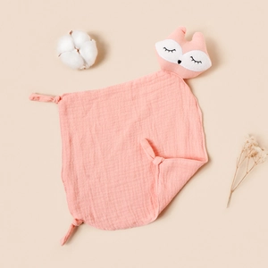 Close-up of a soft peach muslin baby fox lovey with knotted corners and cotton decor