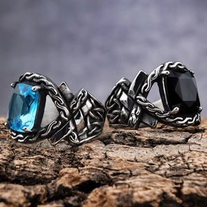 Gothic stainless steel men's rings with square blue and black gemstones on rustic wood