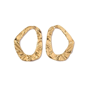 Detailed macro view of golden hammered finish oval earrings with metallic texture