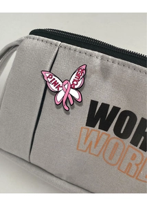 Makroaufnahme der Pink Power Schmetterling-Emaille-Anstecknadel mit rosa Schleife Logo