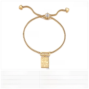 Detail of gold box chain bracelet with engraved rectangular pendant and heart slide