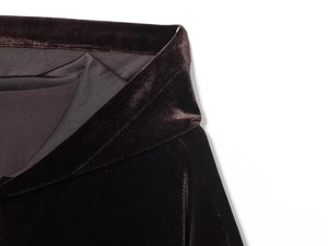 Dettaglio ravvicinato della texture in velluto scuro e delle cuciture per tuta di lusso