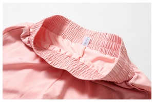 Détail macro de la taille élastique du short de yoga rose avec étiquette d'entretien