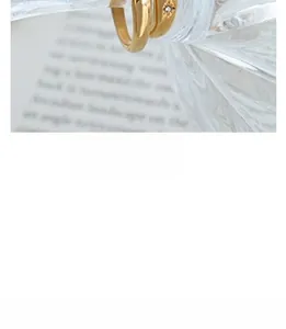 Close-up of gold-plated ring featuring engraved star patterns and small embedded crystals
