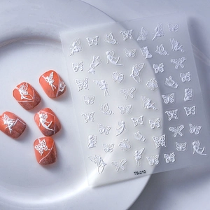 5D embossed nail art stickers featuring white butterfly and fairy patterns on peach glitter