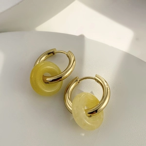 Detailed close-up of 18K gold-plated hoop earrings with yellow natural stone pendant