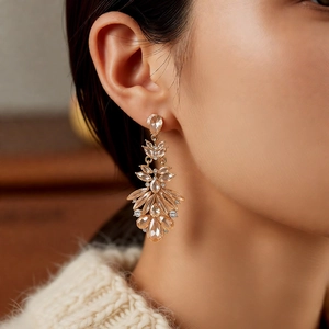 Detailed close-up of crystal leaf tassel earrings with sparkling champagne stones