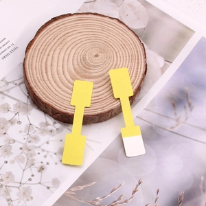 Yellow T-shaped kraft paper jewelry price tags on a decorative wooden base