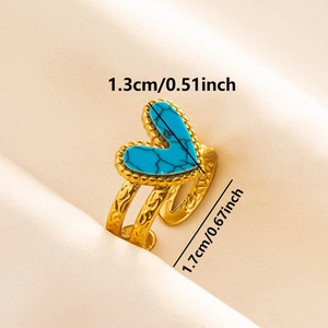 Detail of vintage gold heart ring with turquoise stone and ornate engraved band on silk