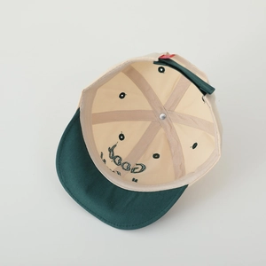 Internal view of a color-block kids baseball cap showing seam stitching and 6-panel structure