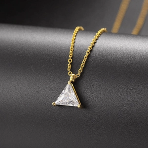 Makroaufnahme von Dreiecks-Zirkon-Anhänger mit Goldfassung an einer feinen Gliederkette