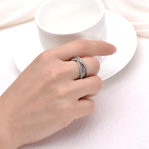 Close-up of matte silver interlaced multi-layer ring with pave-set zircon on model's hand