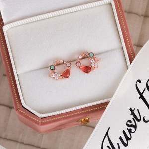 Detail of rose gold flower earrings with pink gems in a pink velvet jewelry box
