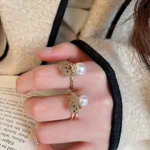 Detail of 18K gold plated rings featuring brown flocked bears and white pearls