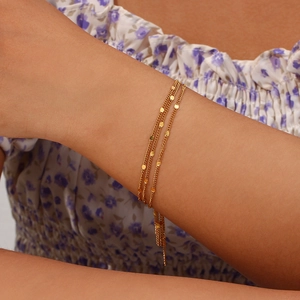 Chic 18K gold plated multi-layer sequin tassel bracelet on woman's wrist with floral dress
