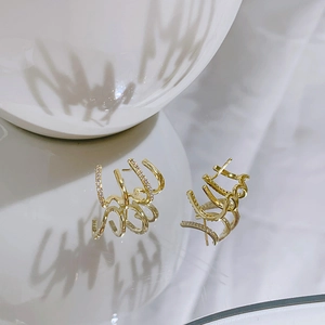 Modern layered gold-plated four-prong stud earrings with cubic zirconia inlay on white ceramic