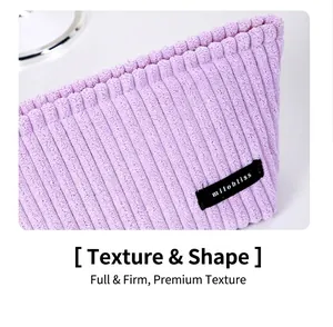 Detailed macro shot of purple corduroy fabric texture and a small woven side label