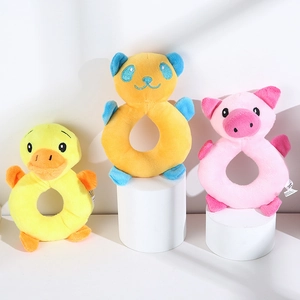 Close-up of plush animal ring rattles with soft fabric and cartoon duck pig and bear designs