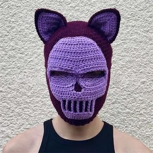 Detail of handmade crochet balaclava with cat ears and skeleton pattern in purple