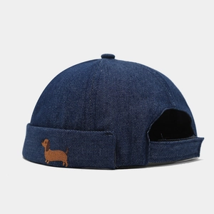 Détail de la broderie de teckel sur le bonnet de docker en denim bleu marine foncé
