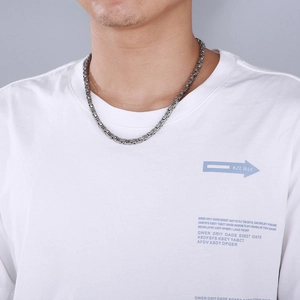 Detail of interlocking stainless steel square Byzantine chain necklace on male model
