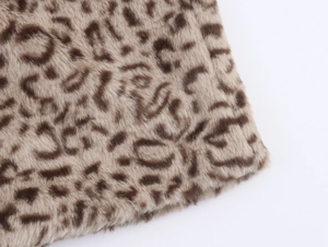Close-up detail of plush faux fur texture with classic brown leopard print pattern