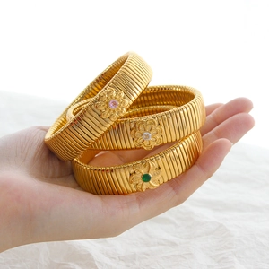 Three-piece set of gold Tubogas bracelets with colorful floral gemstone accents