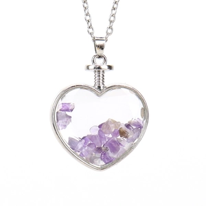 Macro shot of heart-shaped pendant with purple natural stone chips and silver chain