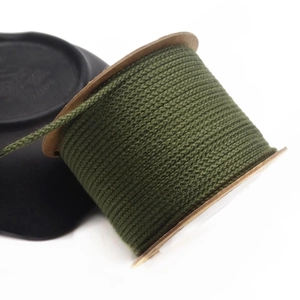 Detail of 1.5mm deep green cotton woven cord on a paper spool for DIY jewelry crafts