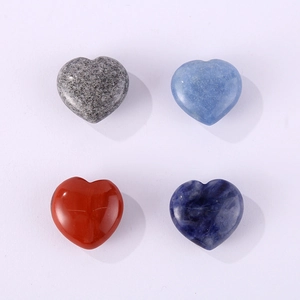 Close-up of four heart-shaped natural stone crystals in blue, red, and grey on white background