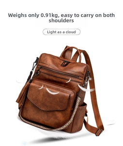 Detail view of vintage brown leather backpack showing lightweight 0.91kg build and tassels