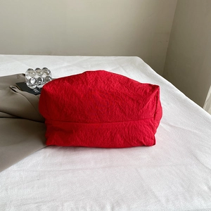 Minimalist red oversized tote bag in pleated nylon fabric with a modern slouchy design