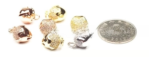 Micro-paved bell pendants in gold and rose gold with white zircon and size reference coin