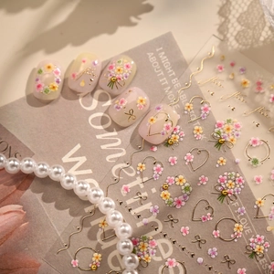 French floral nail art stickers with gold hearts and pink flower patterns on clear tips