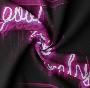 Detail of neon good vibes only print on thick black fabric with artistic folds