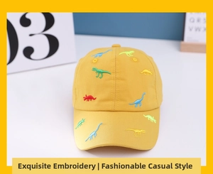 Detailed close-up of yellow cotton cap with colorful dinosaur embroidery patterns
