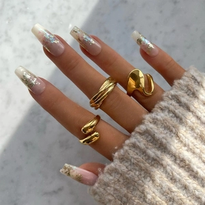 Close-up of three 18K gold-plated irregular rings on model's hand with knit sweater