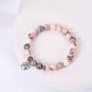 Detail of pink marble stone beads and silver apple pendant on a beaded teacher gift bracelet