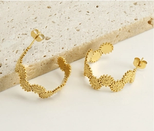 Détail de boucles d'oreilles C en acier doré 18k avec texture de tournesol vintage