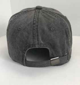 Detail of adjustable metal buckle and washed fabric texture on a dark grey baseball cap